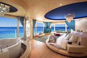 Suite mit Meerblick im Sunrise Arabian Beach Resort mit Badewanne und Bett.