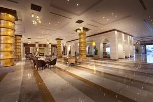 Lobby des Sunrise Arabian Beach Resorts mit goldenen Säulen und Möbeln.