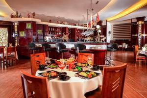 Innenansicht des Restaurants im Pickalbatros Royal Moderna Resort mit voll besetztem Tisch und Bar im Hintergrund.