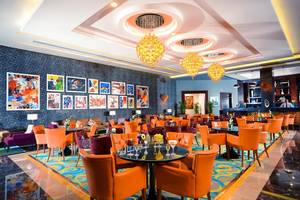 Lobby des Pickalbatros Royal Moderna Resorts mit orangen Stühlen und Tischen.