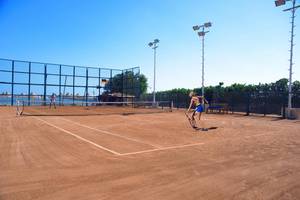 Tennisplatz im Pickalbatros Royal Moderna Resort mit einer Spielerin und einem Netz.