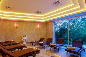 Innenansicht der Sauna im Crystal Waterworld Aqua Collection Hotel mit Lounge-Liegestühlen und Buddha-Statue.