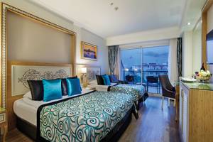 Doppelzimmer mit Balkon im Crystal Waterworld Aqua Collection Hotel, mit zwei Betten und Aussicht auf die Stadt.