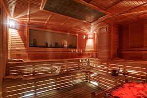 Innenansicht der Sauna im Crystal Waterworld Aqua Collection Hotel mit Holzwänden, Sitzbänken und einem Bild an der Wand.