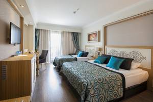 Innenansicht eines Doppelzimmers im Crystal Waterworld Aqua Collection Hotel mit zwei Betten, Fernseher, und Wohnzimmerbereich.