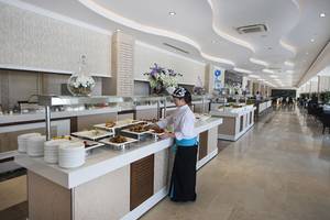 Ein Buffet-Tisch im Hotelrestaurant Crystal Waterworld Aqua Collection mit verschiedenen Gerichten und einer Serviererin.