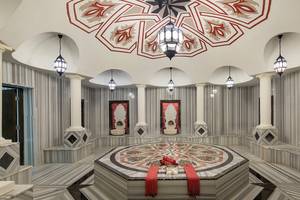 Innenraum des Crystal Waterworld Aqua Collection Spa mit Marmorboden, dekorativen Lampen und zentralem Saunabereich.