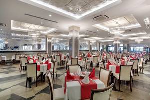 Innenbereich eines Restaurants im Crystal Waterworld Aqua Collection Hotel mit vielen Tischdecken.
