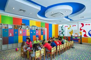 Kinder sitzen um einen Tisch im Spielzimmer des Crystal Waterworld Aqua Collection Hotels.