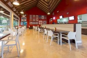 Innenbereich des Marien Puerto Plata Hotels, ein modernes Restaurant mit roten Wänden und weißen Möbeln.