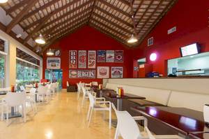 Innenansicht des Marien Puerto Plata Restaurants mit roten Wänden und Tisch-Sitzgruppen.