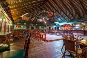 Innenansicht der Bar im Marien Puerto Plata Hotel mit Holzboden, Möbeln und einer Theke.