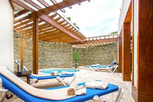 Loungebereich im Marien Puerto Plata Hotel mit Außenpool und Liegestühlen.