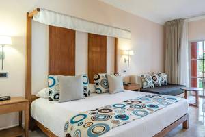 Schlafzimmer im Marien Puerto Plata Hotel mit großem Bett, dekorativen Kissen und moderner Einrichtung.