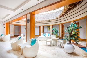 Lounge-Bereich des Marien Puerto Plata Hotels mit weißen Möbeln und Pflanzen.