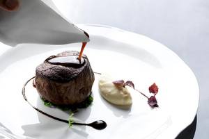 Ein Steakgericht auf einem weißen Teller im Myconian Villa Collection Hotel.