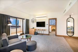 Suite-Zimmer im Le Meridien Abu Dhabi mit Wohnzimmer und Schlafbereich.