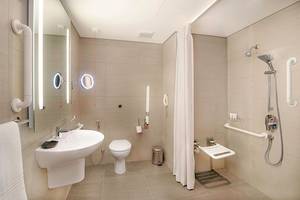 Barrierefreies Badezimmer im Le Meridien Abu Dhabi mit Dusche, Toilette und Waschbecken.