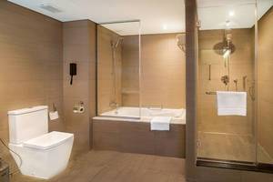 Badezimmer im Le Meridien Abu Dhabi Hotel mit Badewanne und separater Dusche.