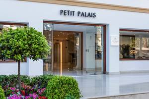 Foto des Eingangsbereichs des Petit Palais Hotels mit Blumen und Pflanzen davor