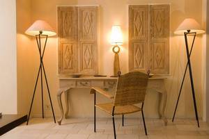 Arbeitsplatz im Zimmer im Marmara Bodrum Hotel mit Schreibtisch, Stuhl, Lampen und dekorativen Türen.