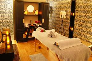 Massageraum im Marmara Bodrum Hotel mit türkisfarbenen Wandfliesen und einem Massagetisch.