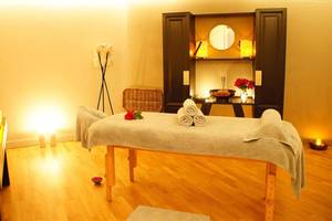 Spa-Behandlungsraum im Marmara Bodrum mit Massagetisch, Kerzen und Dekor.