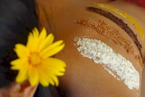Spa-Behandlung im Kuredu Island Resort & Spa mit einer gelben Blume und verschiedenen Hautpflegeprodukten.