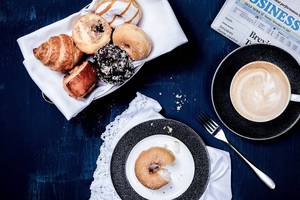 Frühstücksplatte mit verschiedenen Donuts, Croissants und einem Kaffee im Dukes The Palm, a Royal Hideaway Hotel.