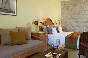 Schlafzimmer im Atlantica Imperial Resort & Spa mit einem Bett, Sofa, Tisch und Dekoration.