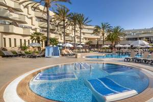 Außenbereich des Hotels Barcelo Corralejo Bay mit Swimmingpool und Liegestühlen