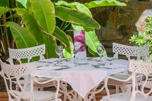 Außentisch im Barcelo Corralejo Bay Hotelgarten mit gedecktem Tisch und Weinglas