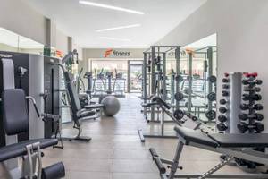 Fitnessbereich im Barcelo Corralejo Bay Hotel mit verschiedenen Trainingsgeräten und Spiegeln.