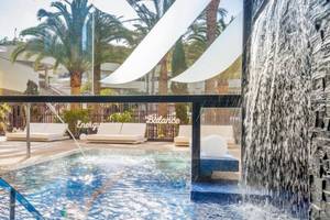 Außenpoolbereich des Barcelo Corralejo Bay Hotels mit Wasserfall und Loungemöbeln.
