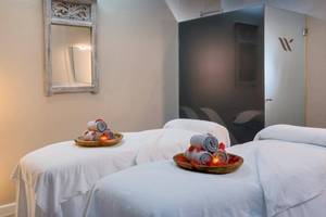 Behandlungsraum im Barcelo Corralejo Bay Hotel mit zwei Massageliegen und einem Spiegel.