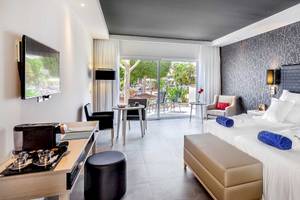 Hotelzimmer des Barcelo Corralejo Bay mit Doppelbetten, Fernseher und Terrasse.