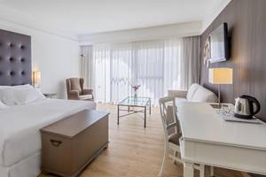 Hotelzimmer im Barcelo Corralejo Bay mit Doppelbett, Wohnzimmerecke und Fernseher an der Wand