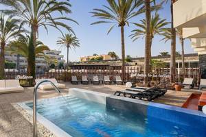Außenpool mit Loungeliegen und Palmen im Barcelo Corralejo Bay Hotel.