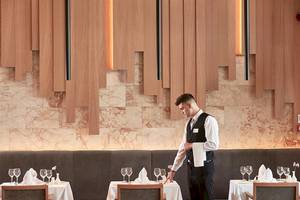 Ein Mitarbeiter des Atlantica Imperial Resort & Spa serviert ein Restaurant.