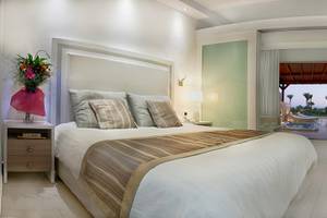 Schlafzimmer im Asterias Beach Hotel mit großem Bett, Fernseher und Nachttischen