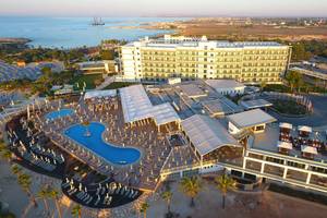 Luftaufnahme des Asterias Beach Hotels mit Swimmingpool und Meerblick.