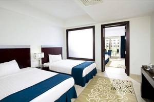 Doppelbett-Zimmer im Serenity Alma Heights Hotel mit Blick auf die Außenterrasse.