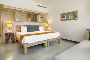 Ein modernes Hotelzimmer mit einem großen Bett, Holzmöbeln und Kunst an der Wand.