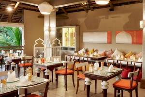 Innenansicht des Restaurants im Zilwa Attitude Hotel mit Tischen, Stühlen und orientalischem Dekor.