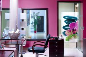 Friseursalon im Michelangelo Resort und Spa mit Stühlen, Schreibtisch und Spiegel.