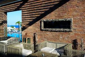 Außenbereich des Michelangelo Resort & Spa mit Blick auf einen Swimmingpool und eine Lounge-Ecke.