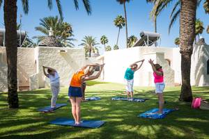 Gruppe von Frauen macht Yoga im Freien im HD Parque Cristobal Hotel.
