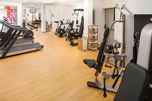 Fitness-Center im HD Parque Cristobal Hotel mit verschiedenen Trainingsgeräten und Holzböden.
