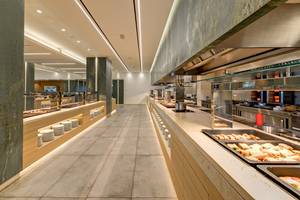 Restaurantbereich im Amada Colossos Resort mit gefliestem Boden und Buffettischen.