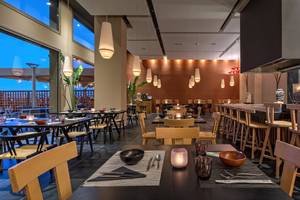 Innenansicht des Restaurants im Amada Colossos Resort mit Tischen, Stühlen und Kerzen.